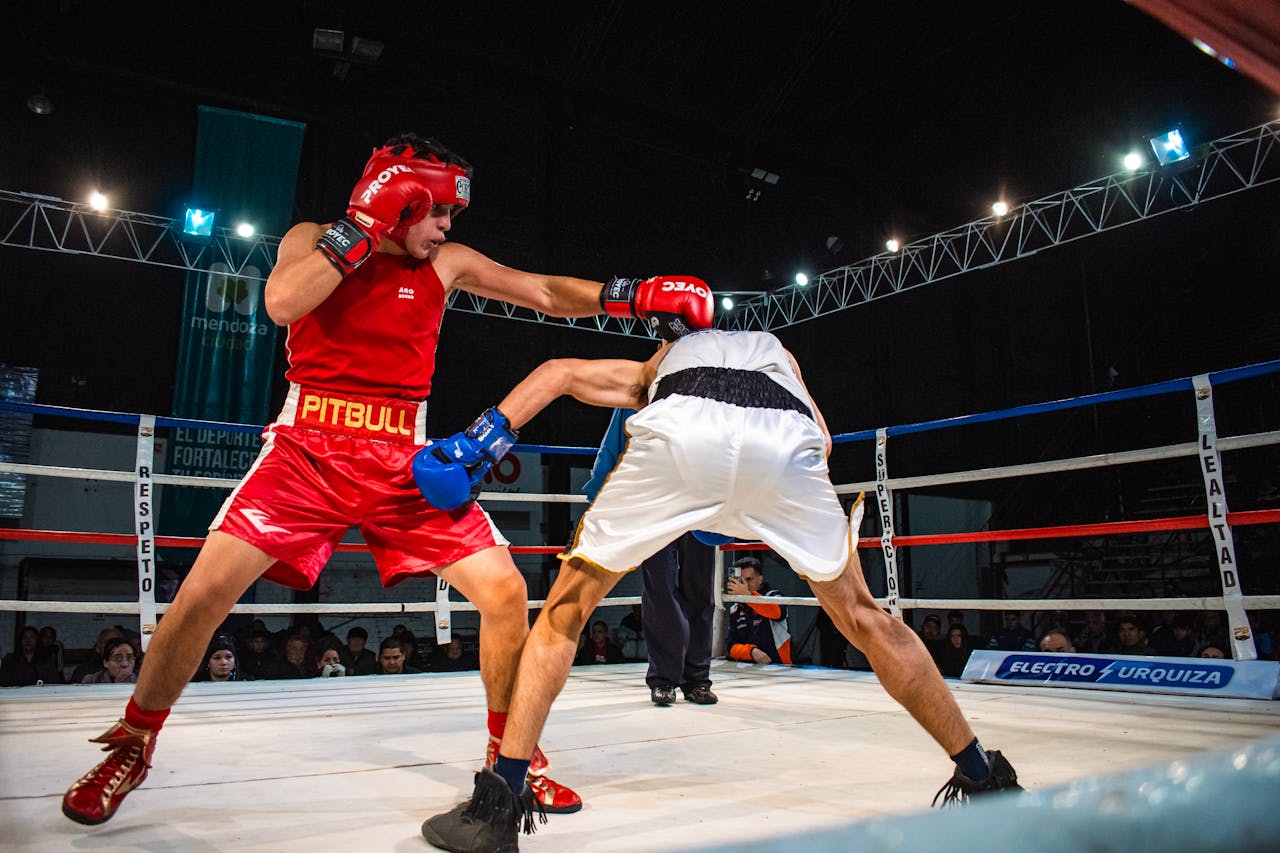 Intense action shot of two male boxers in a lively match, showcasing skill and power.