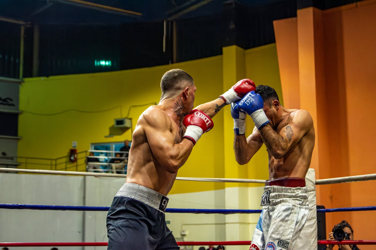 about-us Two professional boxers engaged in an intense match, showcasing strength and strategy.